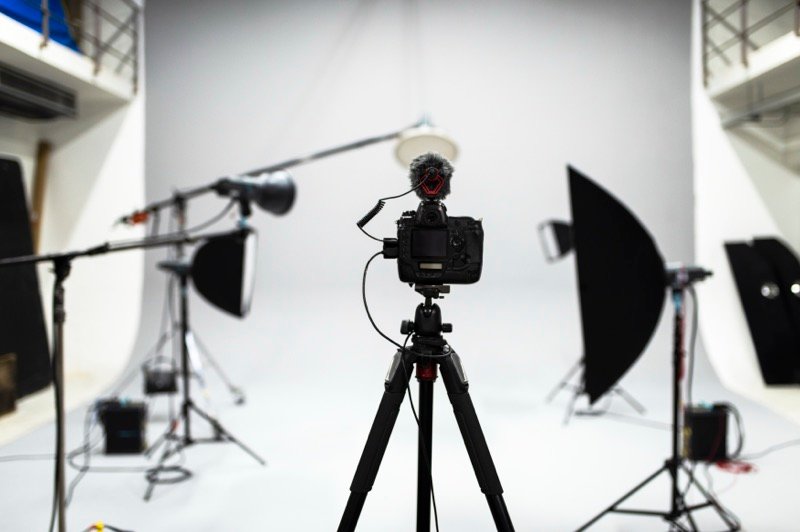A photography studio set up with a camera, lights and softboxes