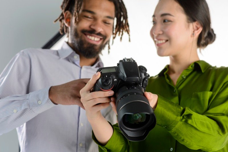 A photography mentor showing a student how to use a camera